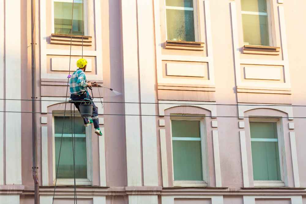 Mann reinig Fassade mit Hochdruckreiniger